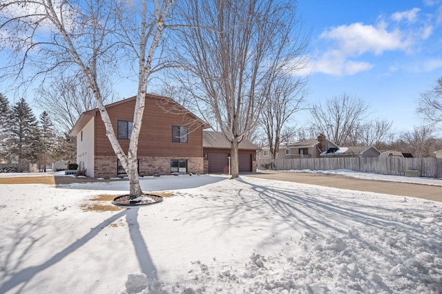 exterior space with a garage, brick siding, and fence