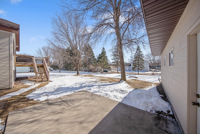 yard covered in snow featuring a wooden deck