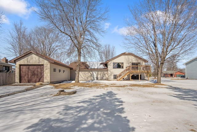 view of front of home featuring stairway, a detached garage, a deck, and fence