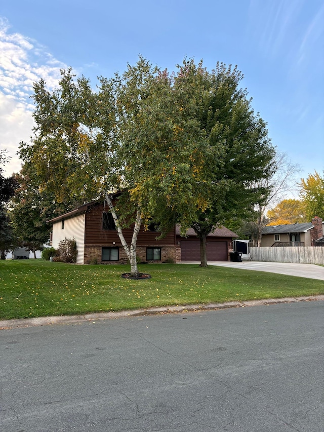 view of front of home featuring aphalt driveway, a garage, a front yard, and fence