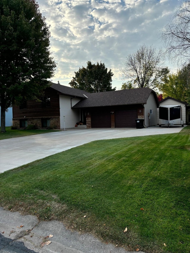 view of front facade with stone siding, a garage, driveway, and a front lawn