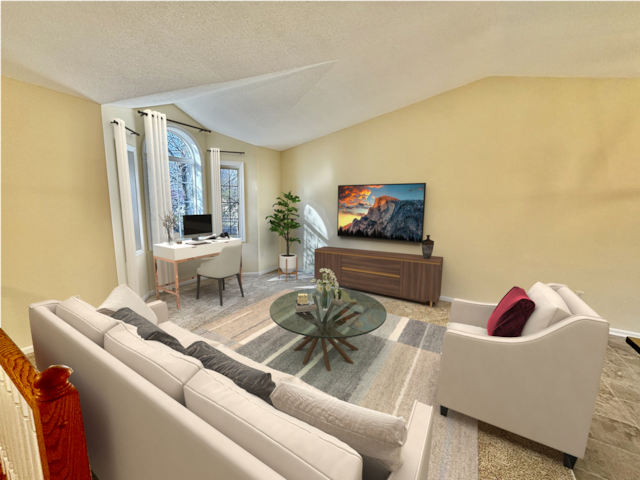 living area featuring a textured ceiling, baseboards, and vaulted ceiling