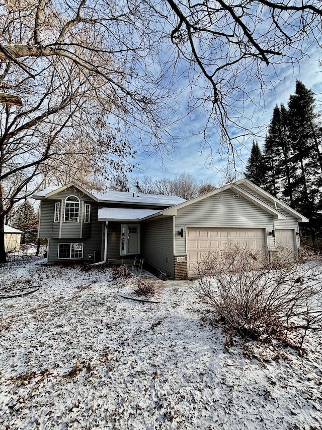 tri-level home featuring an attached garage and brick siding