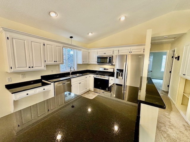 kitchen featuring lofted ceiling, recessed lighting, a sink, stainless steel appliances, and white cabinetry