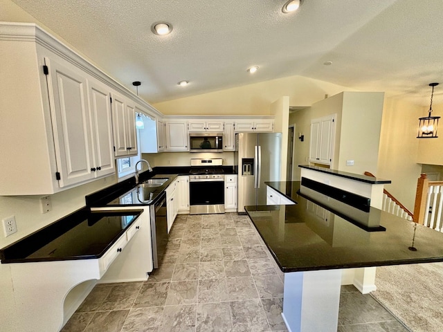 kitchen with pendant lighting, dark countertops, stainless steel appliances, white cabinets, and vaulted ceiling