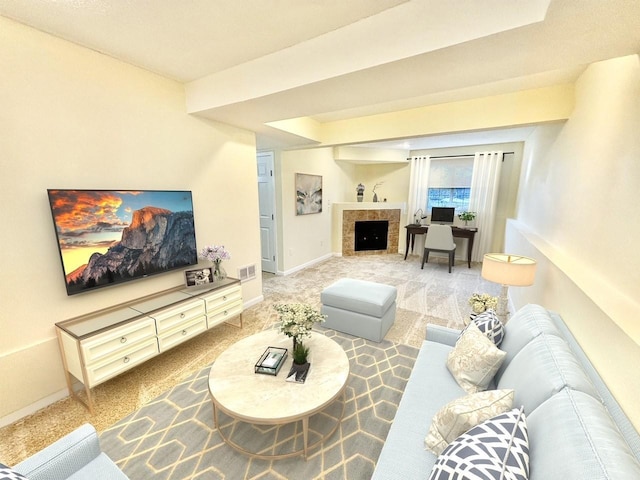 living area featuring visible vents, baseboards, a fireplace, and carpet flooring