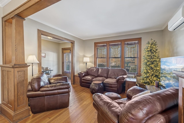 living room with light wood-type flooring, decorative columns, an AC wall unit, and ornamental molding