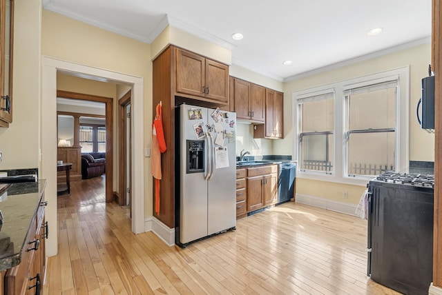 kitchen with light wood finished floors, brown cabinetry, appliances with stainless steel finishes, and ornamental molding