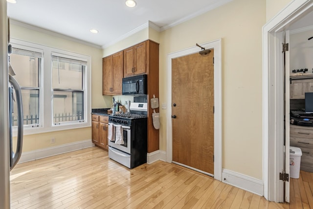 kitchen featuring light wood finished floors, ornamental molding, brown cabinetry, black microwave, and stainless steel range with gas stovetop