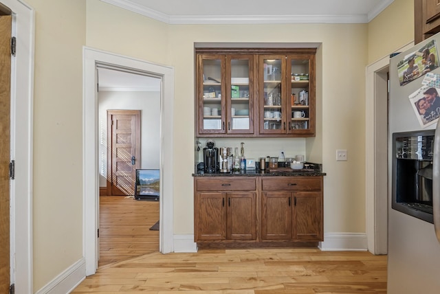 bar with light wood-type flooring, baseboards, stainless steel fridge, and ornamental molding