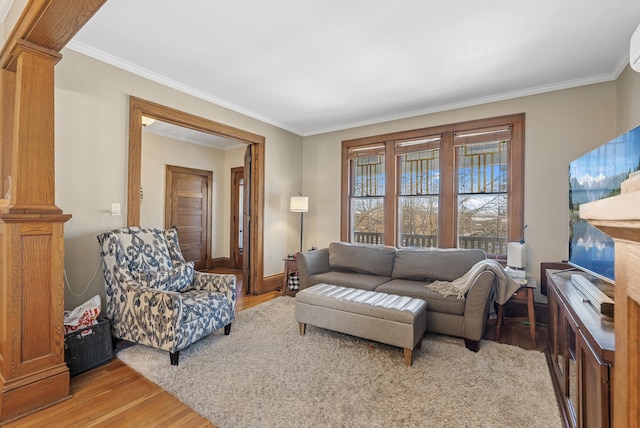 living room with light wood-style flooring, decorative columns, and ornamental molding