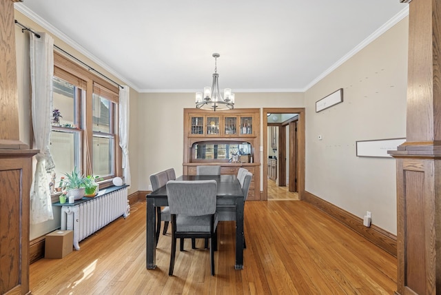 dining space featuring baseboards, a chandelier, radiator heating unit, ornamental molding, and light wood-style flooring