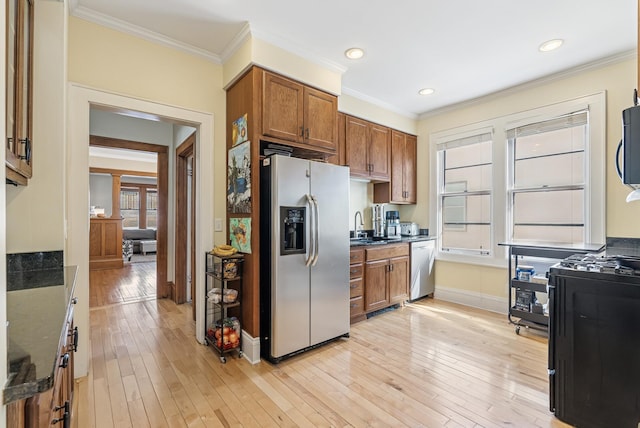 kitchen featuring light wood-type flooring, stainless steel appliances, brown cabinetry, and crown molding