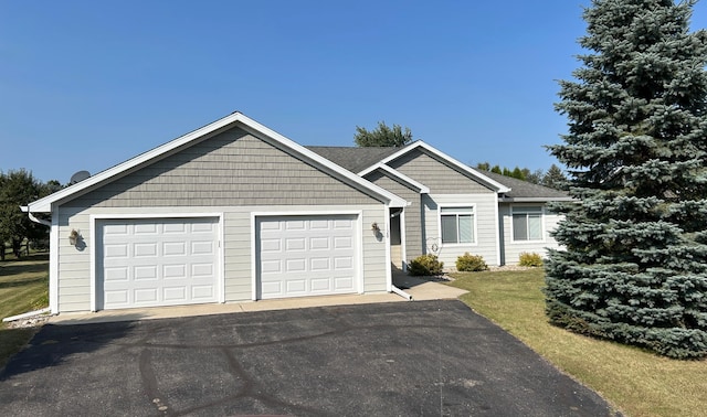 ranch-style house with a garage and aphalt driveway