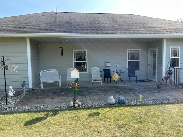 back of house with a patio area, a shingled roof, and a yard