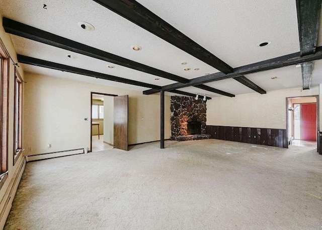 unfurnished living room featuring a baseboard radiator, a fireplace, and beamed ceiling