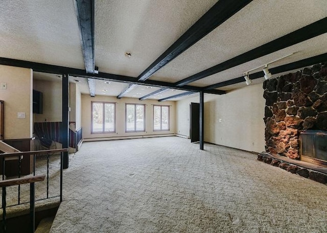 carpeted living area with a baseboard heating unit, beam ceiling, a fireplace, and a textured ceiling