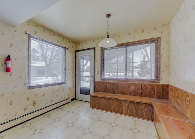 unfurnished dining area featuring light floors, baseboard heating, and wallpapered walls