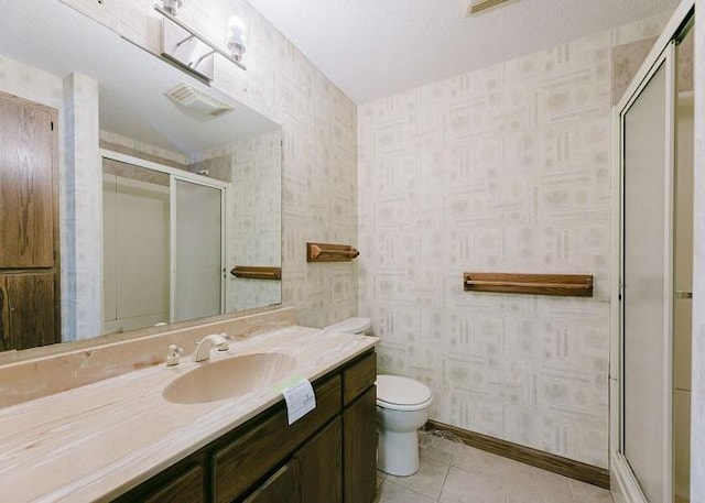 bathroom featuring a stall shower, wallpapered walls, toilet, and tile patterned floors