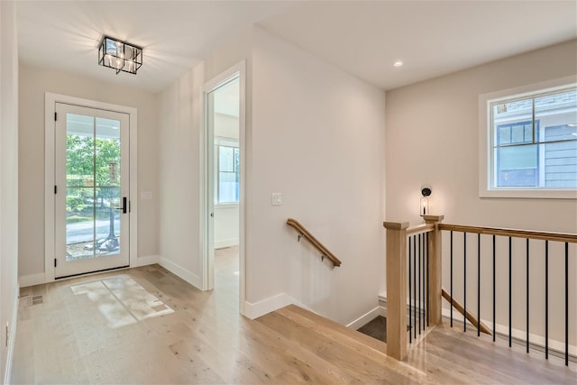 doorway featuring recessed lighting, wood finished floors, visible vents, and baseboards