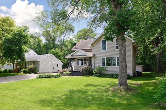301 Lake St, Waconia, MN 55387 - view of front of house featuring covered porch, a front lawn, concrete driveway, and central AC