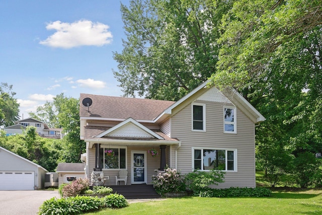 301 Lake St, Waconia, MN 55387 - victorian-style house featuring a porch, an outdoor structure, a front yard, a shingled roof, and a detached garage