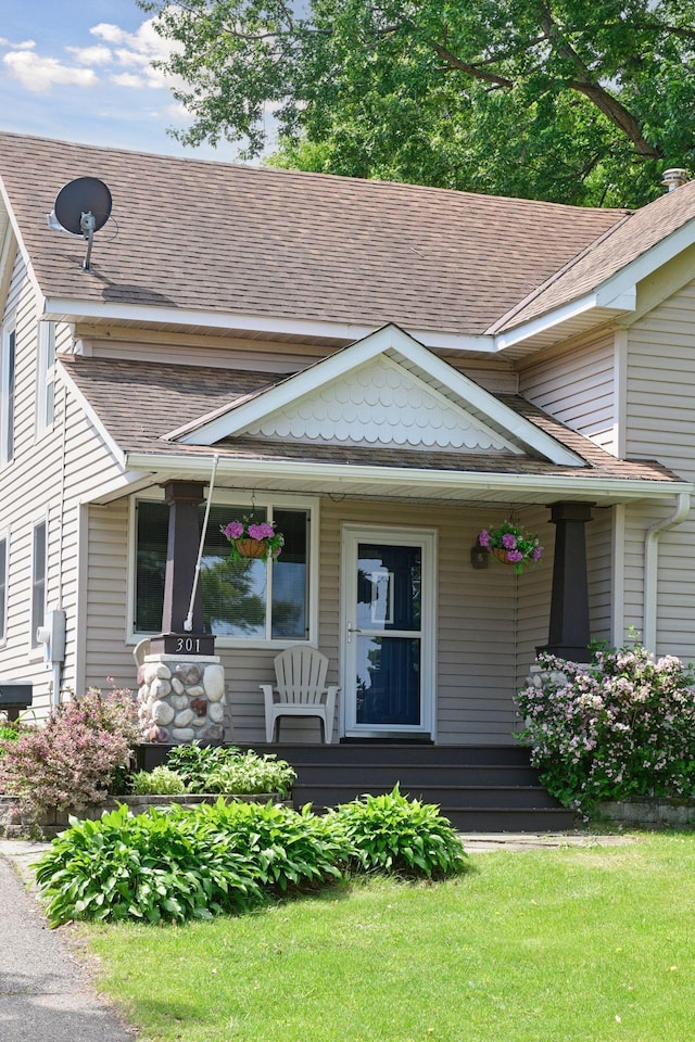 301 Lake St, Waconia, MN 55387 - view of front of house featuring covered porch, roof with shingles, and a front yard