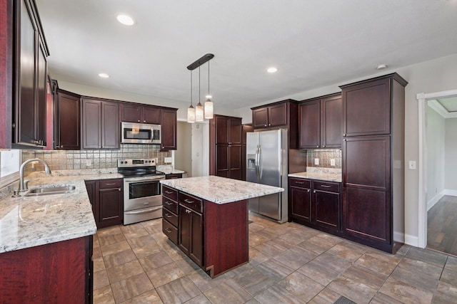 301 Lake St, Waconia, MN 55387 - kitchen featuring appliances with stainless steel finishes, a sink, decorative backsplash, a center island, and light stone counters