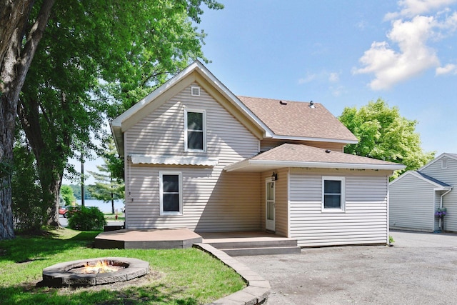 301 Lake St, Waconia, MN 55387 - back of house featuring an outdoor fire pit, a shingled roof, a lawn, and a patio area
