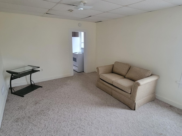 living area with carpet floors, a drop ceiling, and baseboards