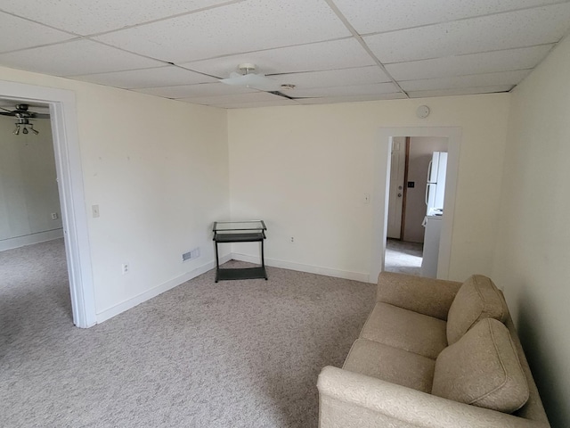 interior space with carpet, baseboards, and a drop ceiling