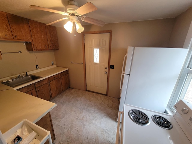 kitchen with electric stove, brown cabinets, a sink, and light countertops