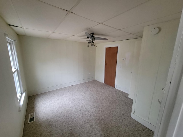 unfurnished room featuring carpet floors, ceiling fan, visible vents, and a drop ceiling