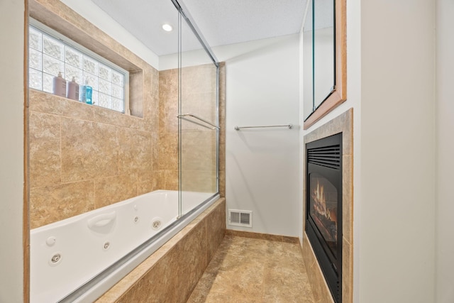 bathroom with baseboards, visible vents, and a glass covered fireplace