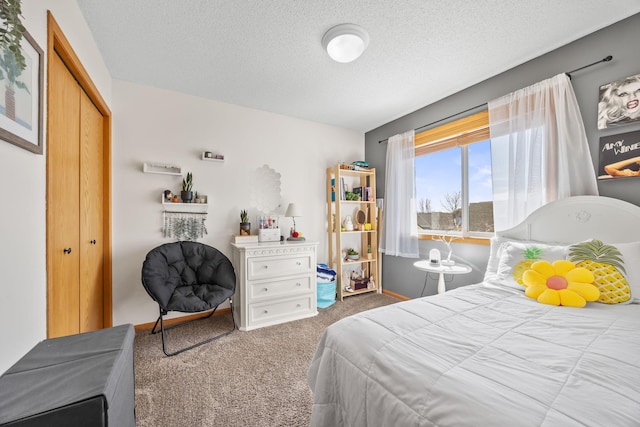 carpeted bedroom with a closet, a textured ceiling, and baseboards