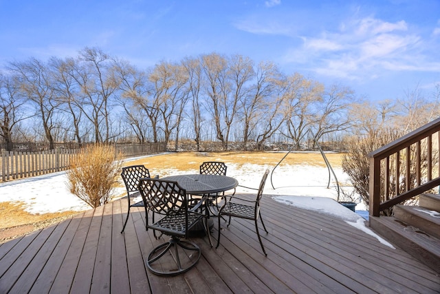 snow covered deck featuring fence and outdoor dining area