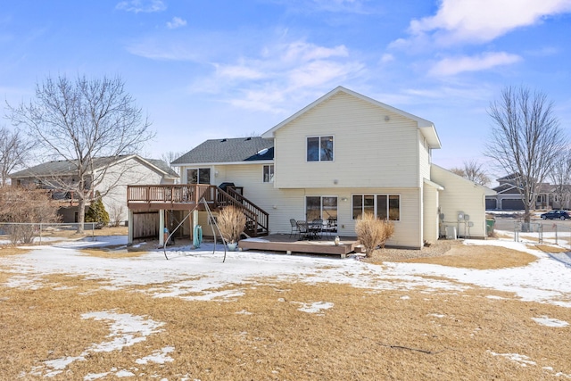 snow covered property featuring fence and a wooden deck