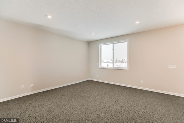 empty room with recessed lighting, baseboards, and dark colored carpet