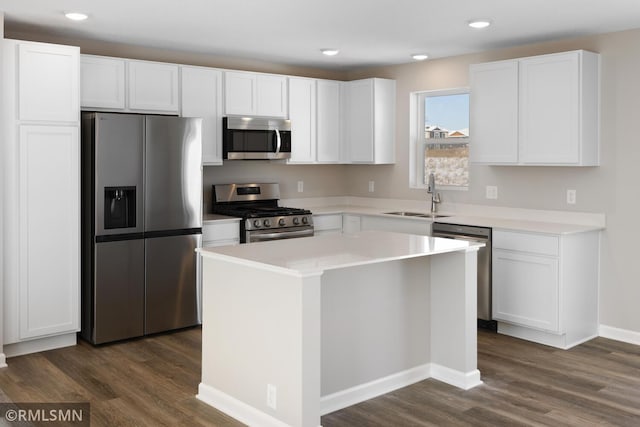 kitchen with dark wood-type flooring, white cabinetry, stainless steel appliances, and a sink