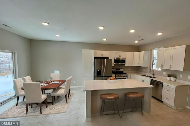 kitchen featuring a center island, plenty of natural light, stainless steel appliances, and a sink