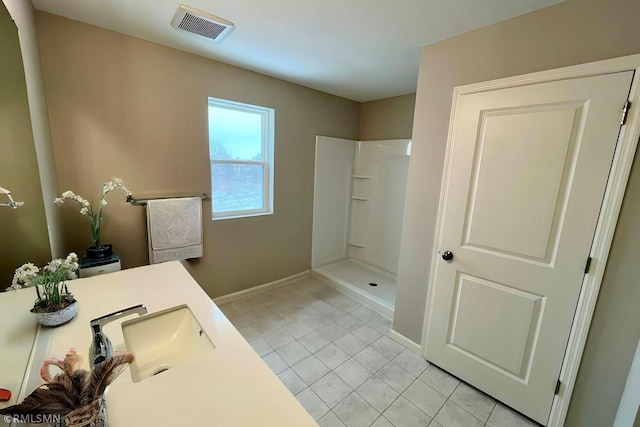 bathroom with vanity, visible vents, baseboards, a walk in shower, and tile patterned floors