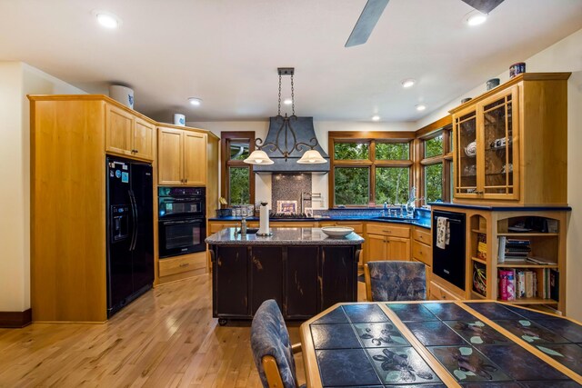 35365 Boot Lake Rd, Park Rapids, MN 56470 - kitchen with a center island, light wood finished floors, backsplash, a sink, and black appliances