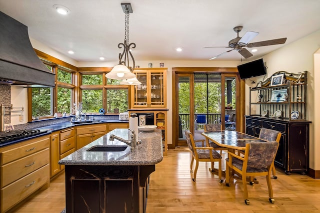 35365 Boot Lake Rd, Park Rapids, MN 56470 - kitchen featuring light wood finished floors, black cooktop, a kitchen island with sink, a sink, and premium range hood