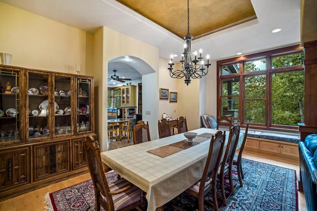 35365 Boot Lake Rd, Park Rapids, MN 56470 - dining space featuring a ceiling fan, arched walkways, a raised ceiling, and wood finished floors