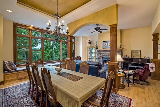 35365 Boot Lake Rd, Park Rapids, MN 56470 - dining space featuring decorative columns, visible vents, a raised ceiling, wood finished floors, and a fireplace