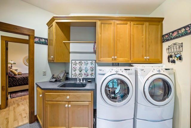35365 Boot Lake Rd, Park Rapids, MN 56470 - clothes washing area featuring light wood-type flooring, washer and dryer, cabinet space, and a sink