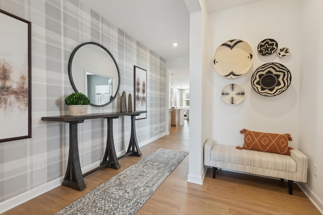 hallway with wallpapered walls, baseboards, wood finished floors, and recessed lighting