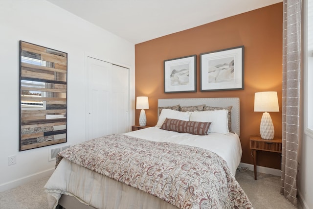 carpeted bedroom with a closet, visible vents, and baseboards