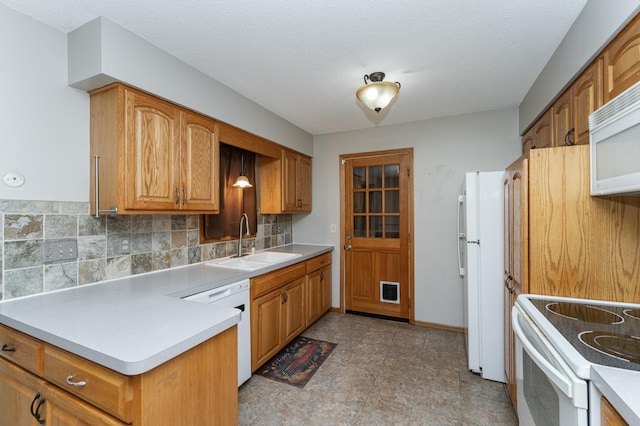 kitchen featuring white appliances, tasteful backsplash, brown cabinetry, light countertops, and a sink