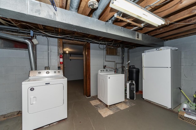 unfinished below grade area featuring independent washer and dryer and freestanding refrigerator